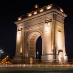 Illuminated Triumphal Arch in Bucharest, Romania, captured at night.